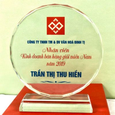 Ảnh nguồn mặt tròn pha lê với logo phía trên, nội dung ghi nhận và tên người nhận bên dưới