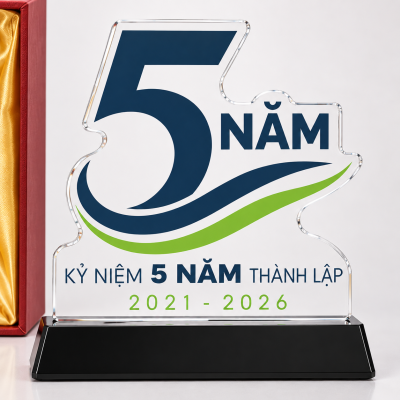 Cận mặt biểu trưng với số 5, chữ NĂM, nét xanh lá và dòng năm 2021–2026