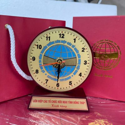 Phương án đồng hồ gỗ mặt đồng với nội dung khác cạnh hộp và túi đỏ trong kho