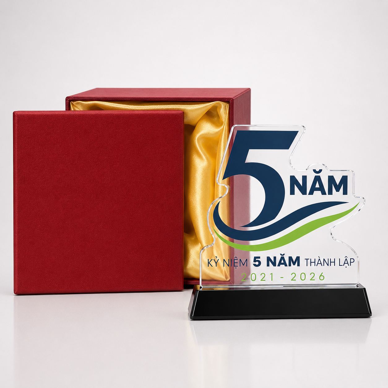 Biểu trưng số 5 đế đen đứng cạnh hộp đỏ nắp trơn và phần lót vàng